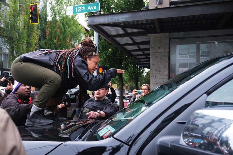 Una manifestante salita su un 'auto durante un corteo a Seattle. Foto d 'archivio © ANSA/EPA