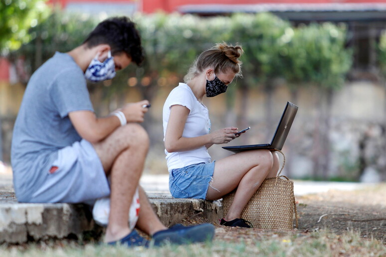 Due giovani collegati al wifi in un parco pubblico - RIPRODUZIONE RISERVATA