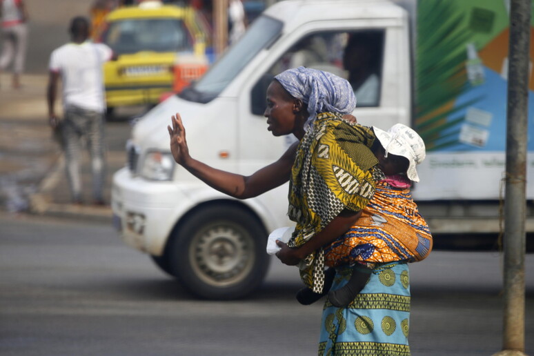 Una donna con un bambino nella fascia in Costa d 'Avorio © ANSA/EPA