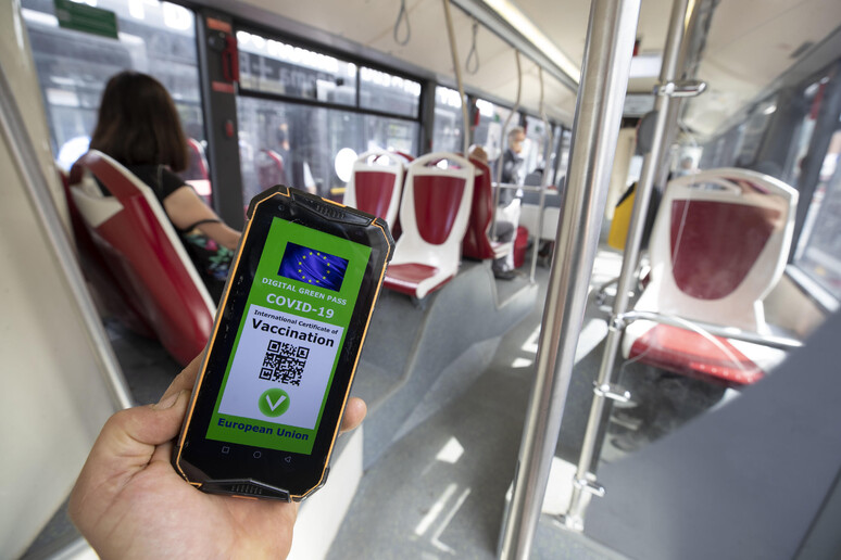 Un Green pass su un cellulare di un passeggero di autobus a Roma - RIPRODUZIONE RISERVATA
