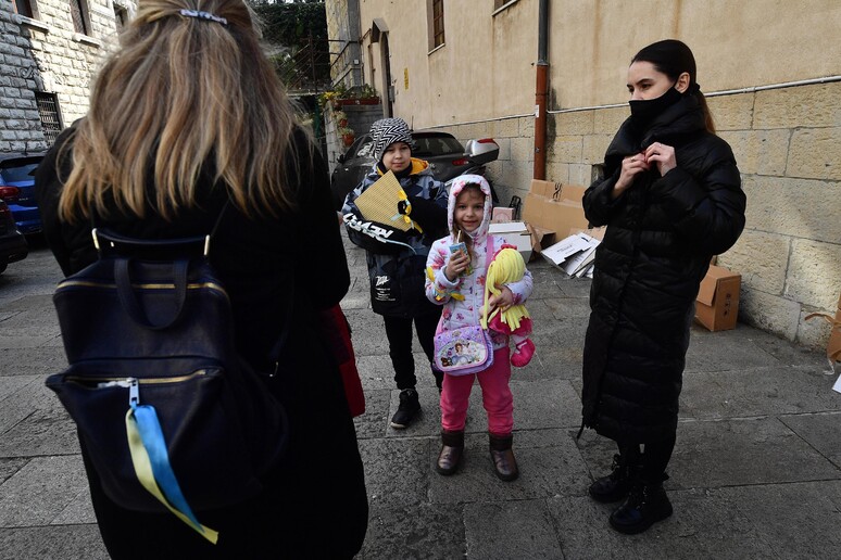 Bambini in attesa davanti al centro di ascolto Caritas a Genova - RIPRODUZIONE RISERVATA