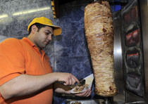 Un uomo prepara un kebab in una foto d'archivio