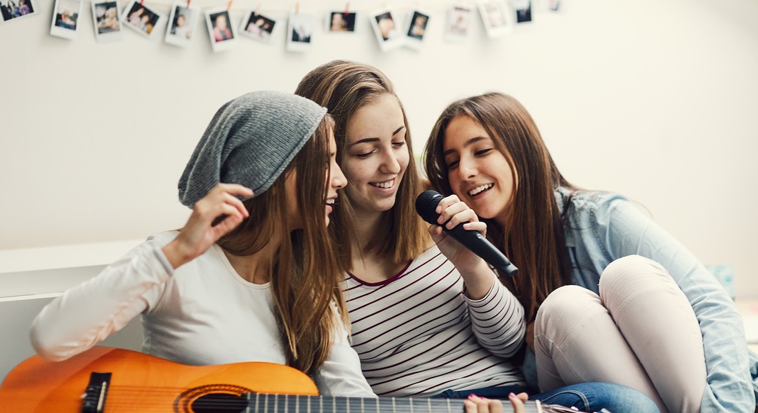 Tre ragazze e il karaoke con lo smartphone. ph. vgajic iStock. © Ansa