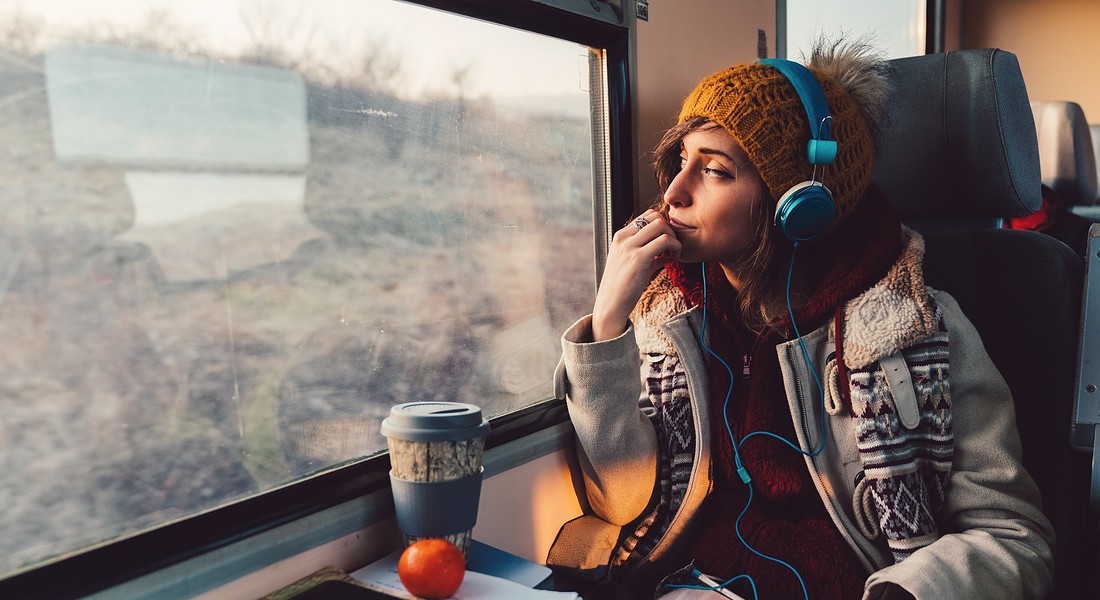 Una donna ascolta musica durante un viaggio in treno foto iStock. © Ansa