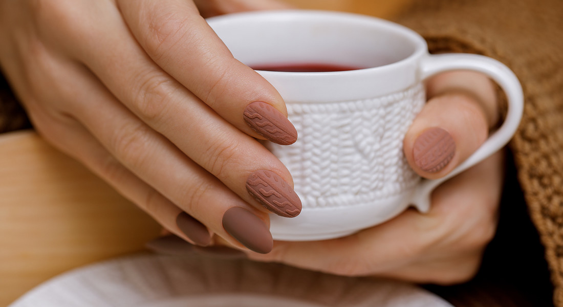 Stylish winter nail design. Knitted fabric texture on women's nails iStock. © Ansa