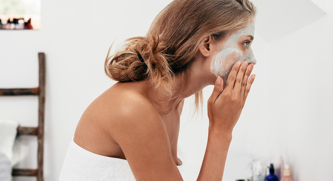 Curare la pelle nel post vacanze. Una donna deterge il viso foto iStock. © Ansa