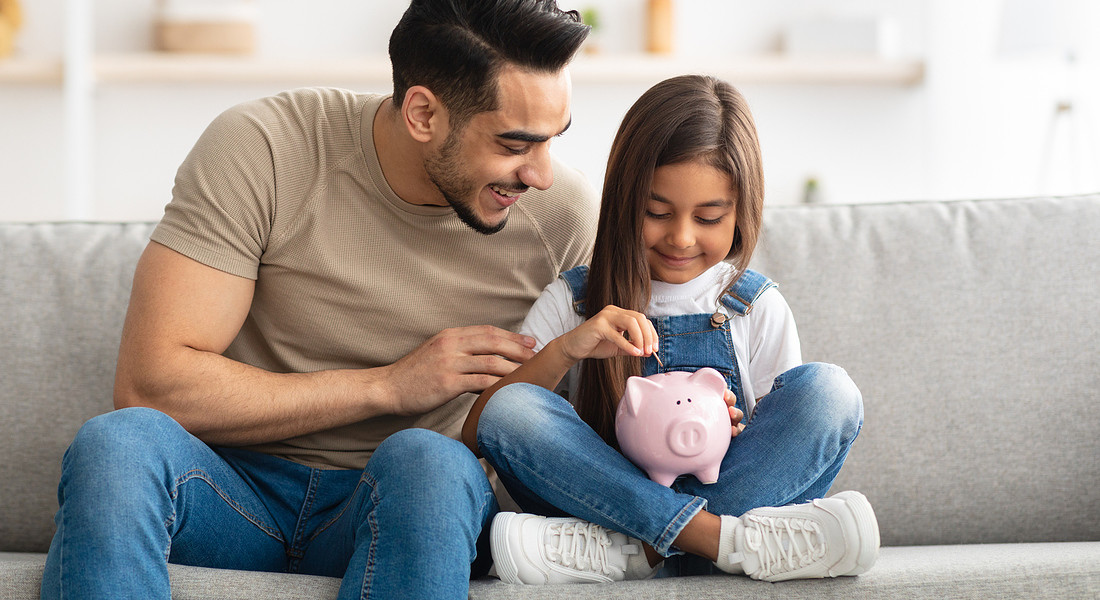 Little girl and dad saving money in piggy bank © Ansa