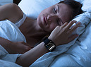 Una donna dorme con al polso uno sleep tool per monitorare il sonno foto iStock. (ANSA)