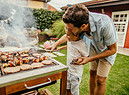 padre e figlio si divertono con il barbecue in giardino. foto iStock. (ANSA)