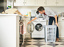 Un uomo carica la lavatrice foto iStock. (ANSA)