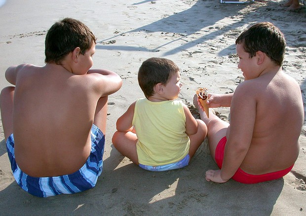 Tre bambini in spiaggia in una foto di archivio © ANSA 