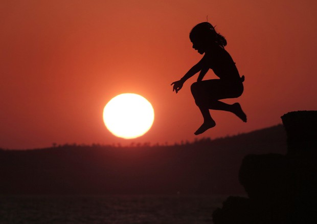 Una ragazza salta al tramonto ad Atene in una foto d'archivio © EPA