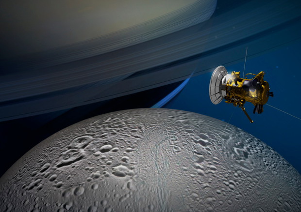 Rappresentazione artistica della sonda Cassini nell'orbita di Saturno, mentre osserva la luna Encelado (fonte: NASA/JPL-Caltech) © Ansa