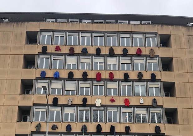 Cappotti appesi alle finestre del palazzo dell'Enea per la campagna ecobonus condomini © Ansa