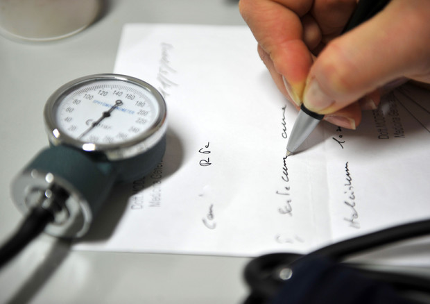 Una dottoressa scrive un certificato medico © ANSA