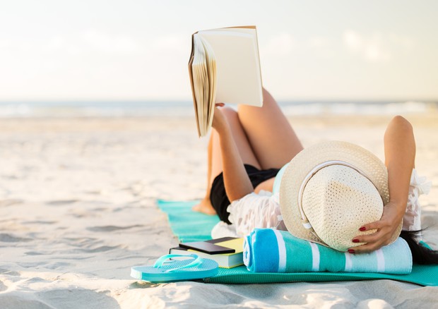 Le vacanze allungano la vita. L'immagine di una donna in relax sulla spiaggia © Ansa