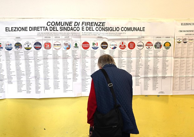 Un elettore osserva i simboli in un seggio nel giorno delle elezioni europee © ANSA