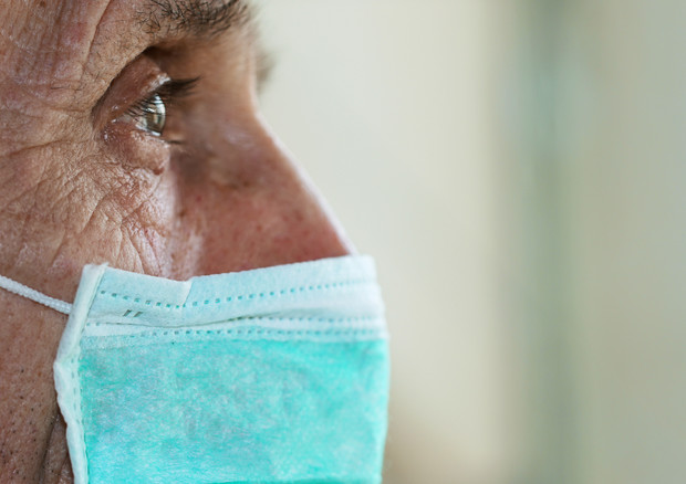 Un paziente in attesa con una mascherina © Ansa