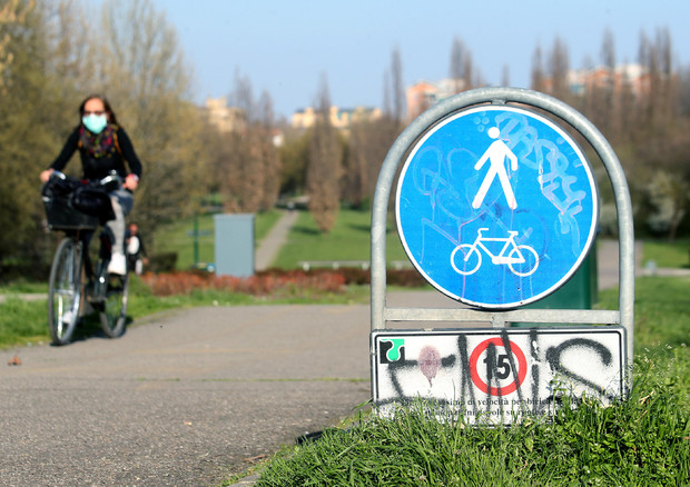 In bici con la mascherina nel parco a nord di Milano © ANSA