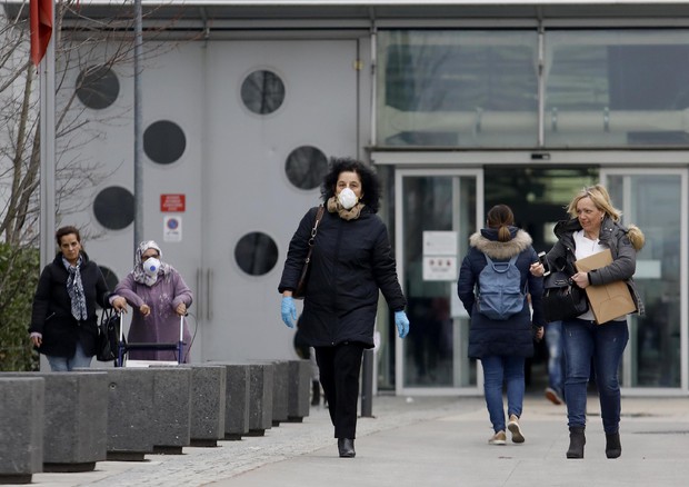 Persone indossamo mascherine protettvie all'esterno dell'ospedale Papa Giovanni XXIII durante l'emergenza Coronavirus a Bergamo © ANSA