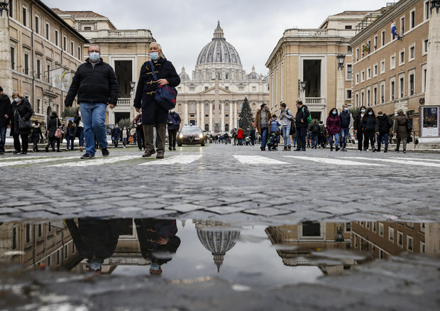 Persone passeggiano lungo Via della Conciliazione a Roma. Immagine d'archivio © ANSA