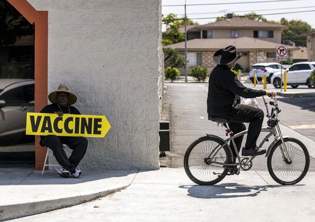 Un uomo indica un centro vaccinale a Los Angeles © EPA