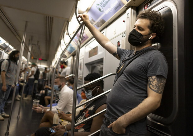 Passeggeri con la mascherina nella metropolitana © EPA