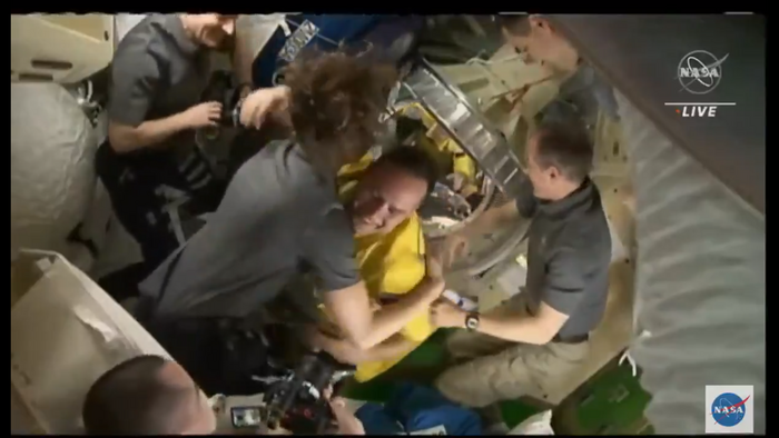 The three Soyuz astronauts on the International Space Station, greeted with smiles and hugs