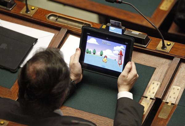L'onorevole Roberto Menia gioca con l'I-Pad mentre il centrosinistra fa ostruzionismo e accortosi di essere fotografato cerca di nascondere il tablet, in aula della Camera