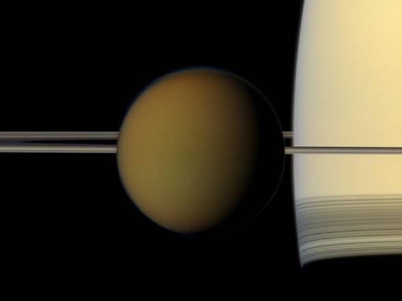Titano visto dalla sonda Cassini, sullo sfondo Saturno con i suoi anelli (fonte: NASA/JPL-Caltech/Space Science Institute)