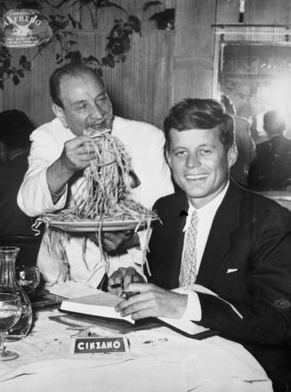 Il presidente americano John Kennedy, in visita a Roma, pranza al ristorante Alfredo, luglio 1963.  Il cameriere serve degli spaghetti al presidente.