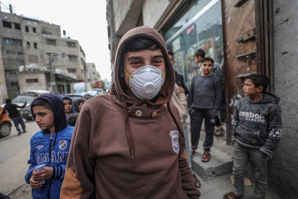 Ragazzini con le mascherine nelle strade di Gaza