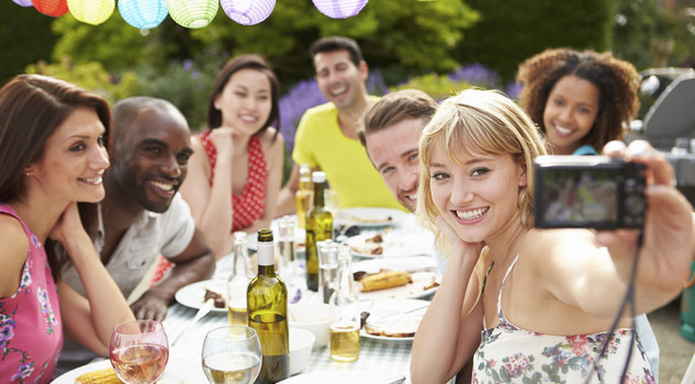 Un gruppo di amici scatta un selfie a tavola