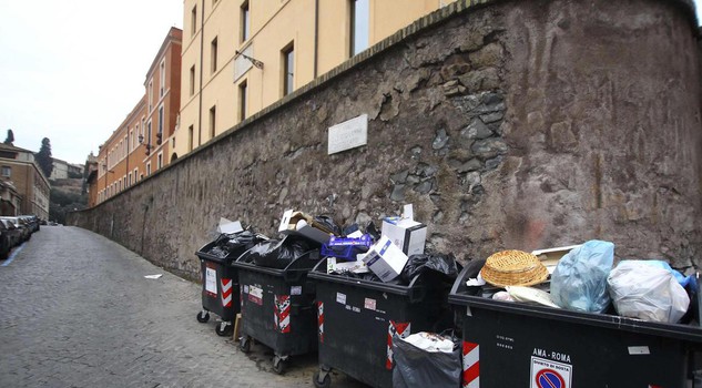 A Roma una strada con i cassonetti stracolrmi di rifiuti alimentari