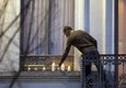 Mohammed Abdeslam, fratello di Brahim, kamikaze del Bataclan, e del ricercato Salah, mette candele per le vittime di Parigi nella sua residenza a Molenbeek © Ansa