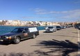 Una fila di carri funebri in attesa di caricare le salme dei migranti morti in mare sulla banchina  del porto di Lampedusa. ANSA/PASQUALE CLAUDIO MONTANA LAMPO © Ansa