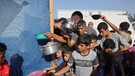 Guerra Medioriente - Rifugiati palestinesi attendono il pasto a Khan Yunis (ANSA)