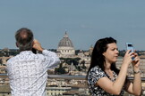 Turistas toman foto desde un punto elevado del centro romano. 