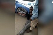 Migrante ammanettato ad auto polizia, IL VIDEO
