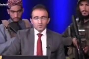 Afghanistan, anchor in studio tv con dietro i Talebani armati