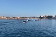 Sbarchi continui a Lampedusa, fila di barchini verso il molo