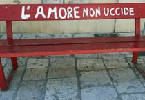 Una panchina rossa con la scritta 