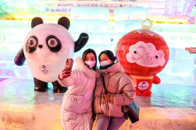 Due ragazze si fanno un selfie davanti alla scultura del panda (ANSA)