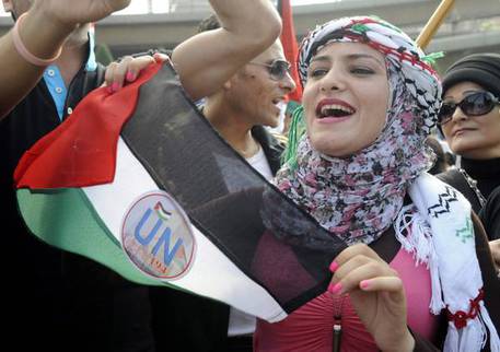 Una ragazza palestinese con la bandiera davanti al palazzo delle Nazioni Uniti a Beirut © ANSA 