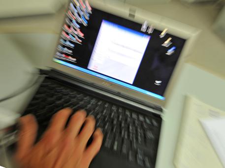 Un uomo utilizza un computer portatile in una foto d'archivio © ANSA 