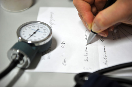 Una dottoressa compila un certificato medico © ANSA