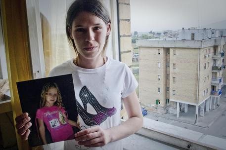 Domenica Guardato, 27 anni, madre di Fortuna, 6 anni, mostra una foto della figlia ritrovata morta / Foto di Ciro Fusco © ANSA
