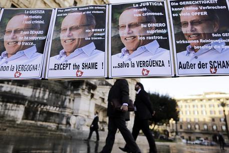 Alcuni cartelli con la foto del miliardario svizzero Stephan Schmidheiny © ANSA