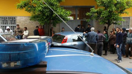 Polizia e curiosi davanti alla palazzina ad Afragola (Napoli) dove una madre ha ucciso il figlio disabile ed ha tentato poi di suicidarsi (foto: ANSA)