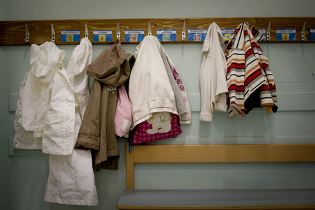 Zainetti e giacche appesi fuori da una classe di scuola elementare. Immagine d'archivio © ANSA 